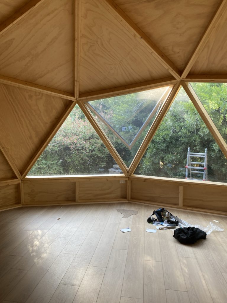 Interior domo geodésico madera, ventanas.