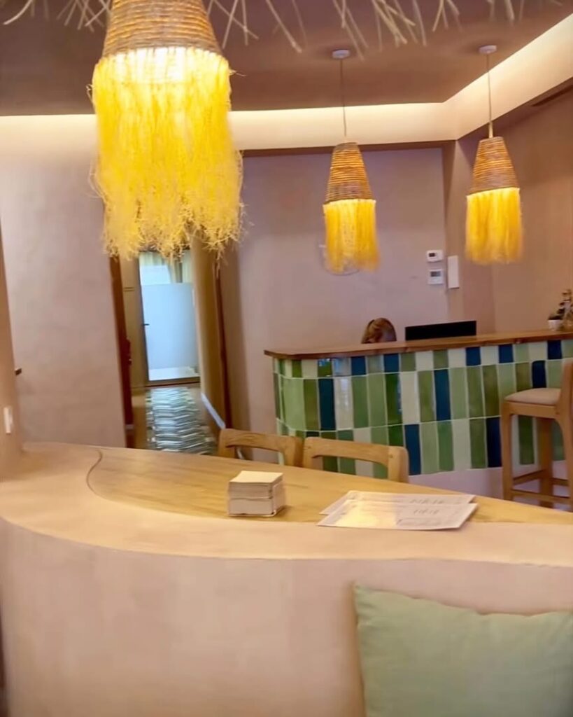 Recepción de la clínica y bar con mesadas de madera color roble. Valencia. GEOFEN