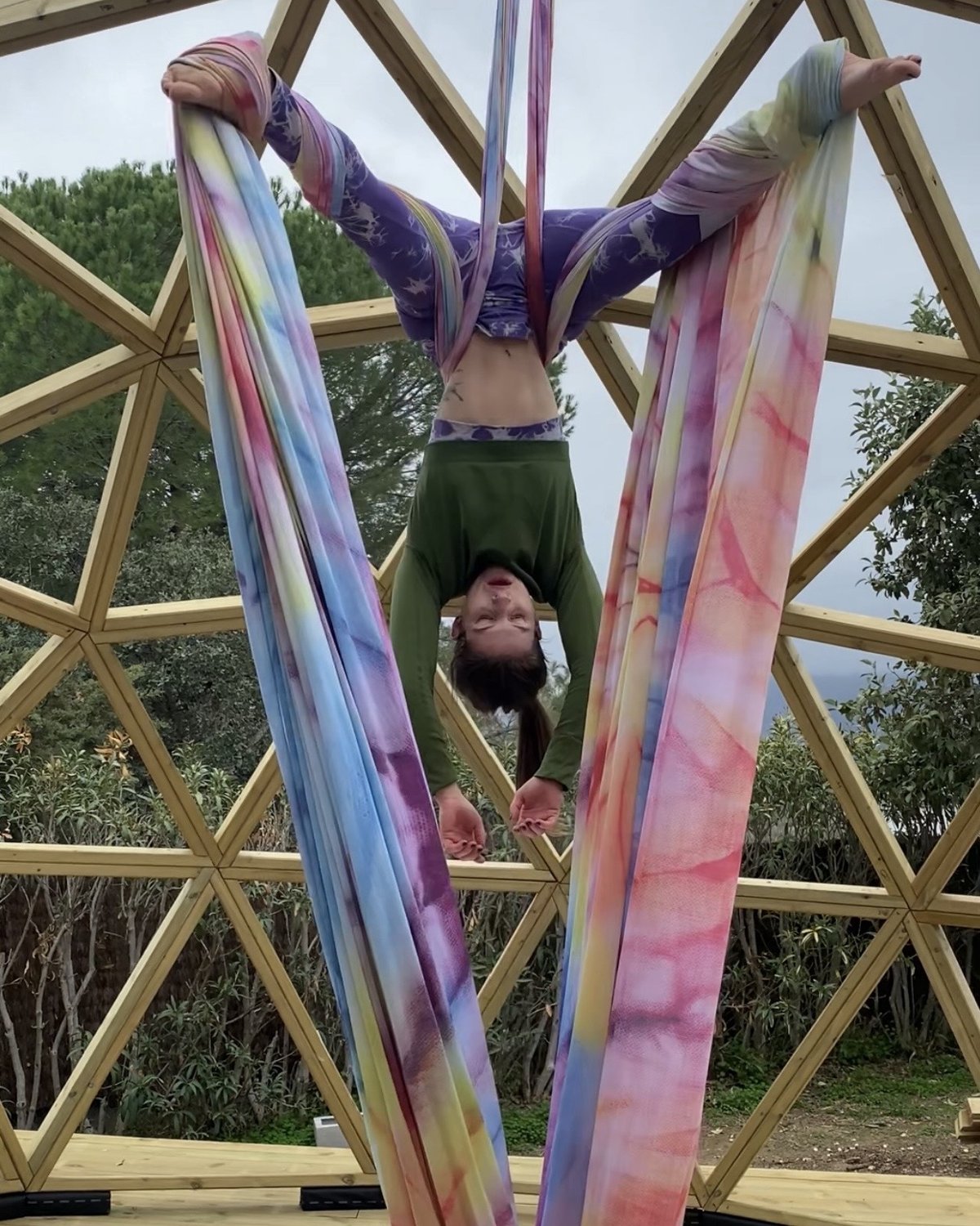 Aerial yoga suspendido en domo geodésico de madera.