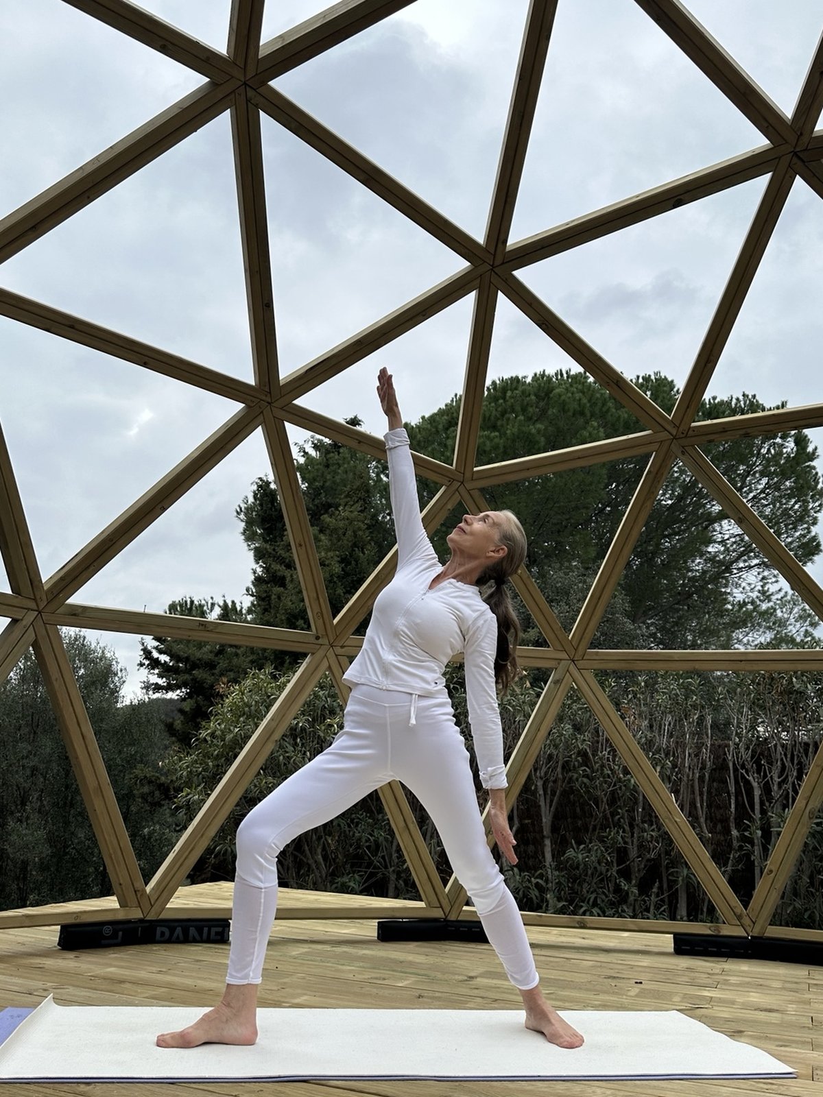 Yoga dentro de domo geodésico de madera diseñado con geometría sagrada.