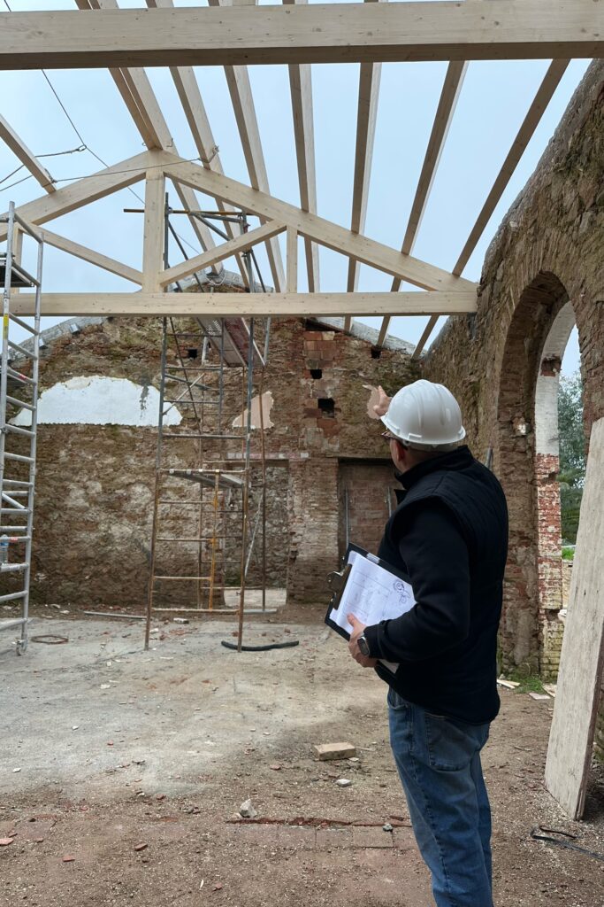 Montaje de vigas y cerchas de madera de 7,70 m de longitud y 2 m de alto en rehabilitación de edificio histórico. Obejo. Córdoba. GEOFEN.
